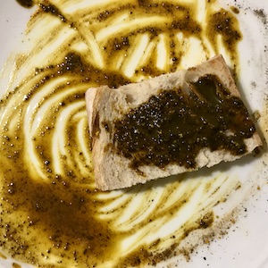 La foto muestra una rebanada de pan tostado untada con una pasta vegetal.