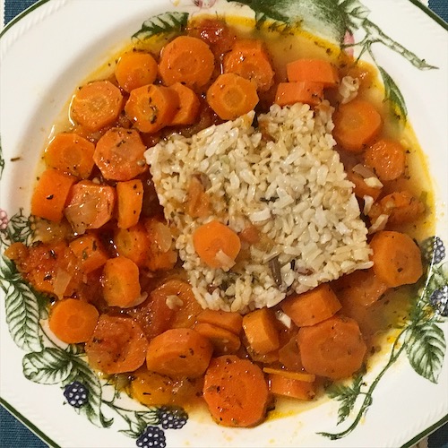 La foto muestra un plato con zanahorias cortadas en forma de disco rodeando a un cuadrado hecho con arroz.